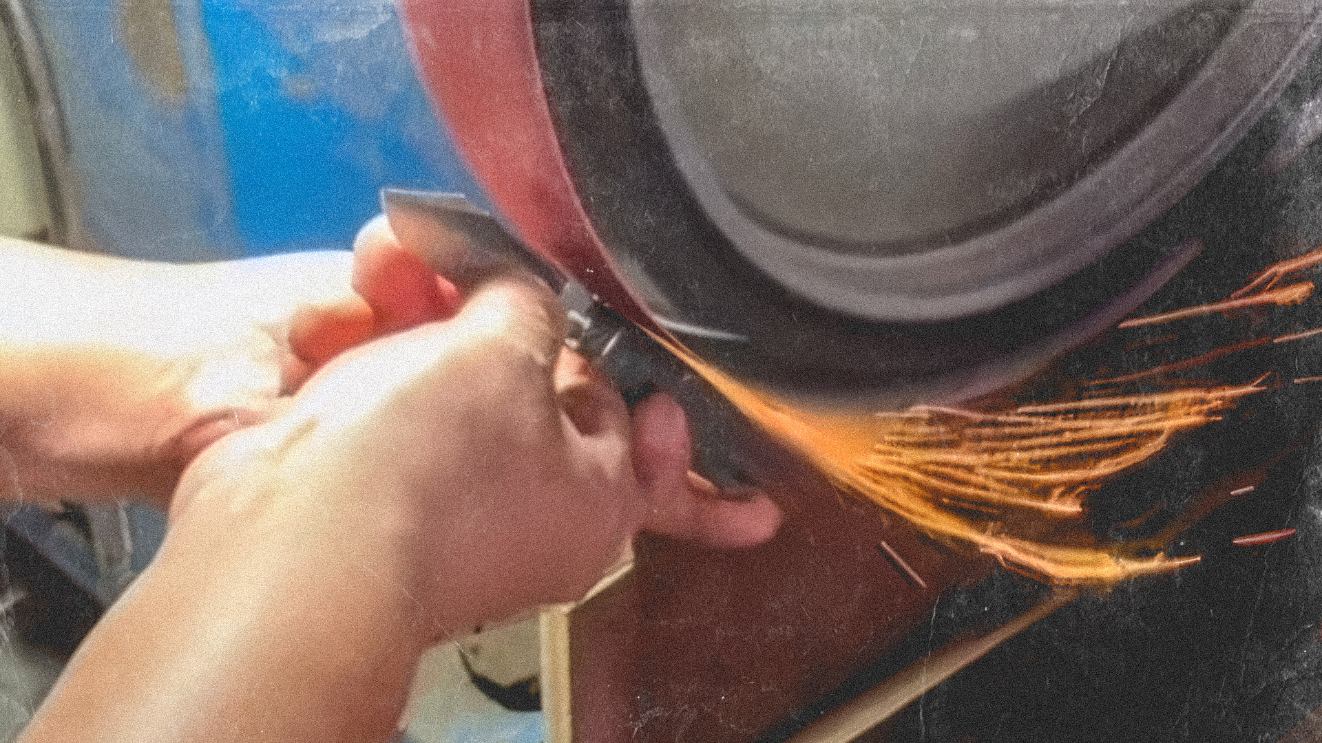 A RoseCraft craftsman works on a slip joint knife on the grinder